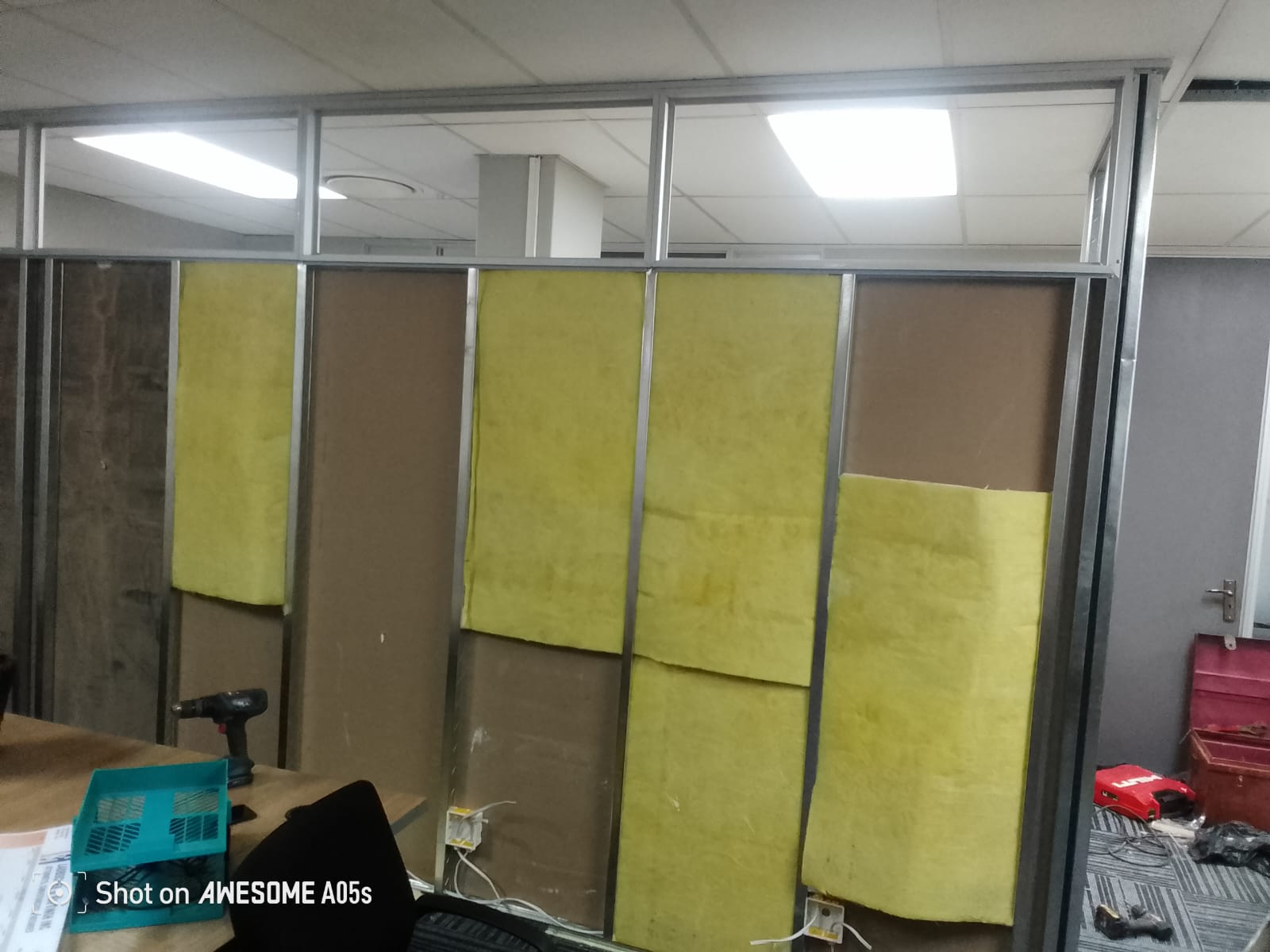 Aluminium-framed office partition with insulation batts, in progress