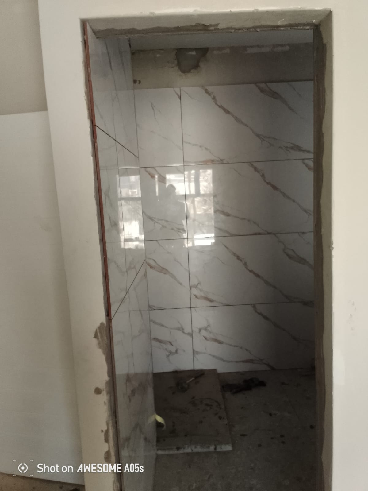 Full marble-look shower enclosure with mixer outlet, near-finished