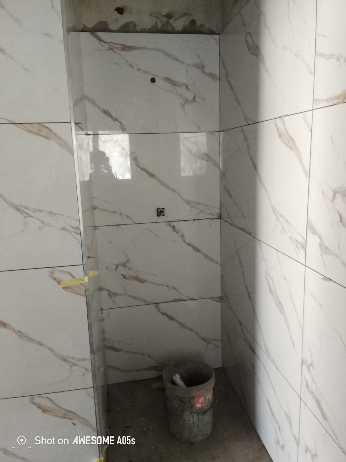Completed grey-tiled room with stacker doors taped for paint