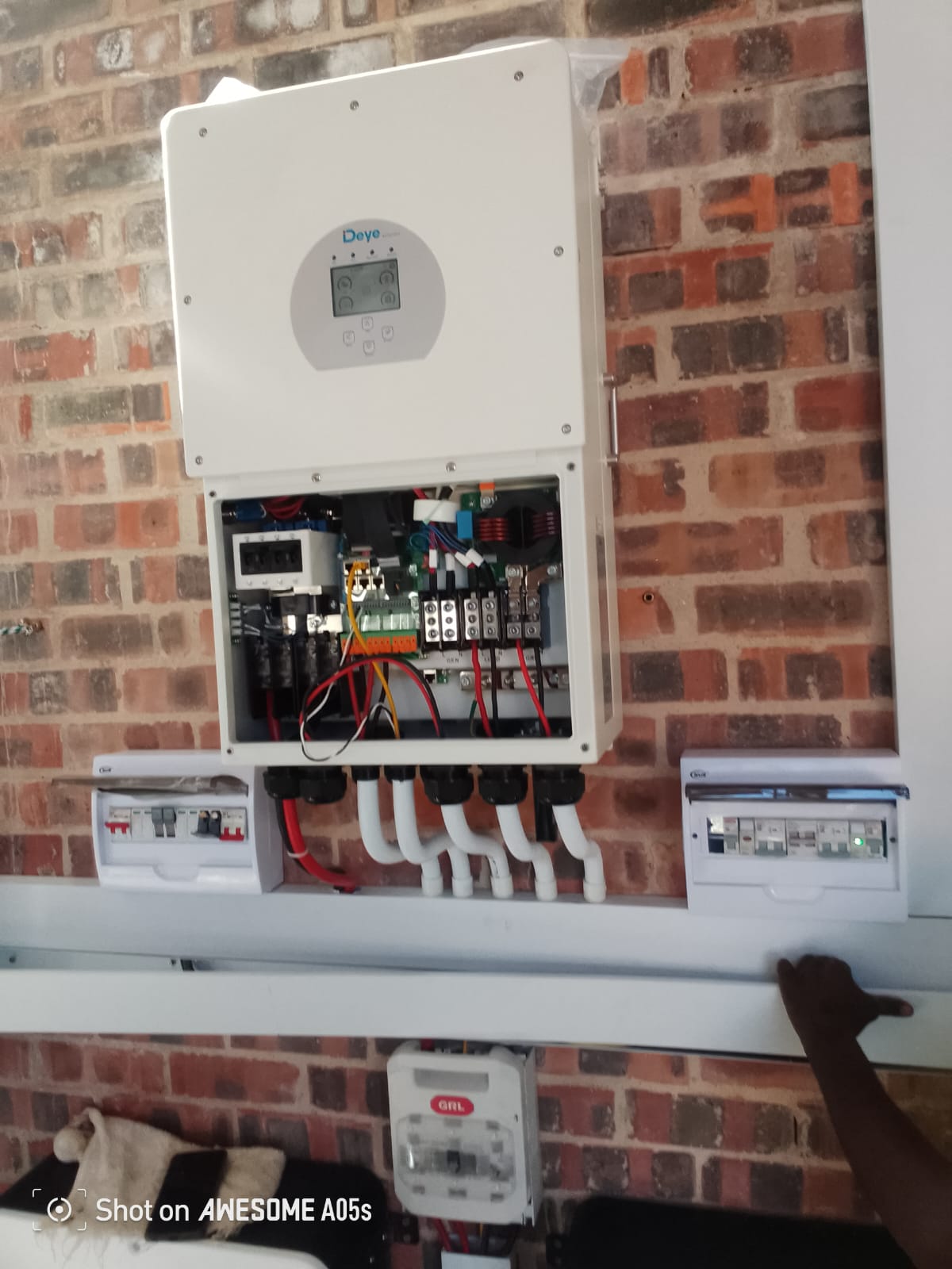 Close-up of a Deye hybrid inverter wired with DC and AC isolators